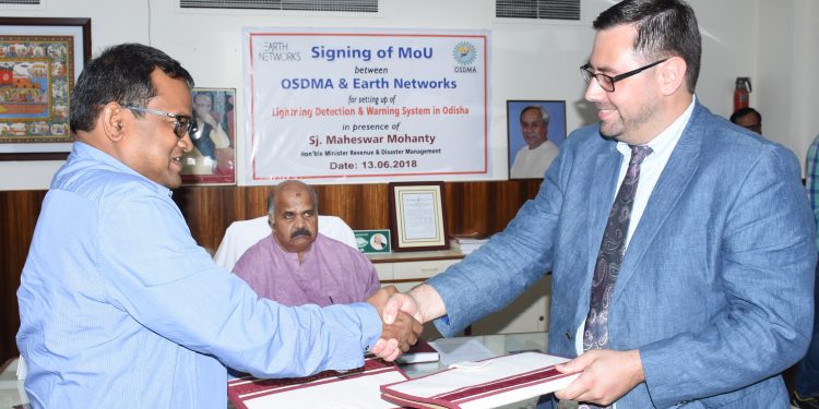 OSDMA managing director Bishnupada Sethi after signing an MoU with a representative of Earth Networks in the 
presence of Revenue and Disaster Management Minister Maheswar Mohanty in Bhubaneswar, Wednesday