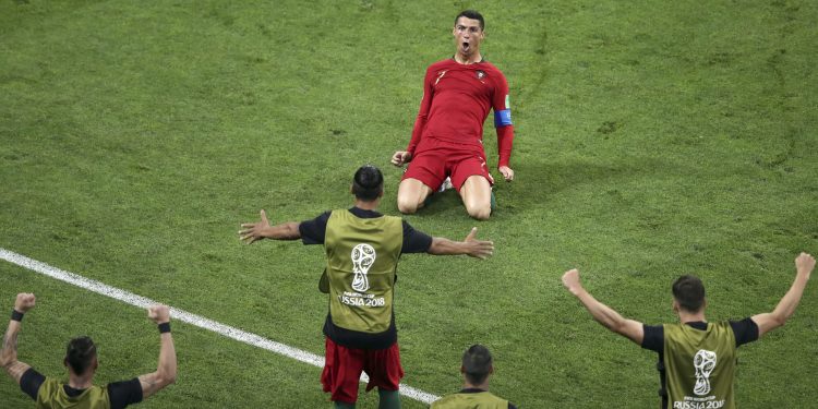 Portugal's Cristiano Ronaldo kneels on the pitch as he celebrates after scoring his side's second goal against  Spain at Fisht Stadium in Sochi Friday