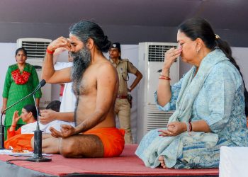 Kota: Yoga guru Ramdev Baba and Rajasthan Chief Minister Vasundhara Raje perform yoga during an event to set the Guinness World Record for 'The Largest Yoga Lesson' during the International Day of Yoga, in Kota on Thursday, June 21, 2018. (PTI Photo) (PTI6_21_2018_000114B)