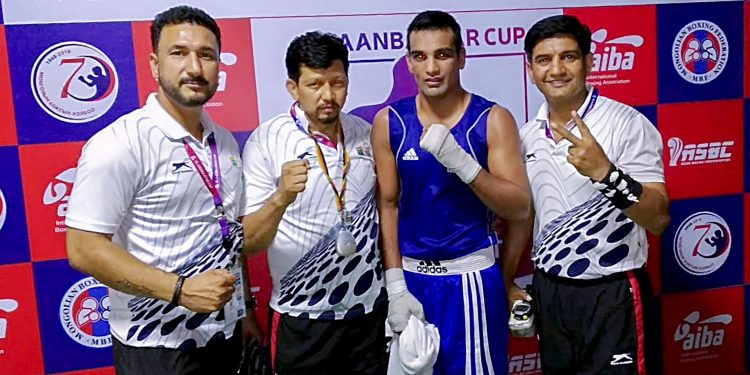 Indian boxer Mandeep Jangra (in blue) poses with officials after winning his quarterfinal bout against Batkhuyag Sukhkhuyag in Mongolia, Friday  