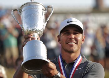 Brooks Koepka holds up the Golf Champion Trophy after winning the US Open Golf Championship, Sunday