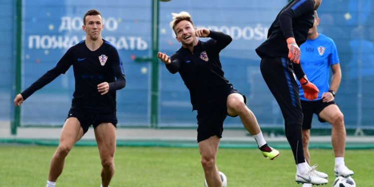 Ivan Rakitic (C) tries to connect a header as teammate Ivan Perisic (L) looks on during Croatia’s training session at the Roshchino Arena near St Petersburg