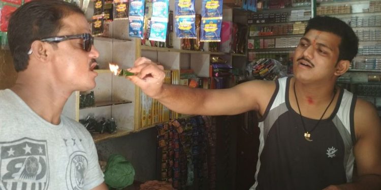 Abhinash Swain helps a customer try a fire paan