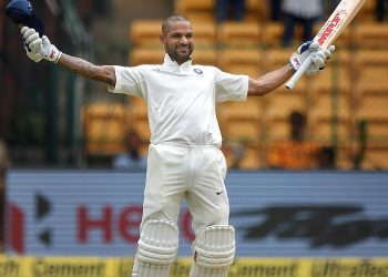 Shikhar Dhawan celebrates his century on the first day of the one-off cricket test match against Afghanistan, at Chinnaswamy Stadium, Thursday