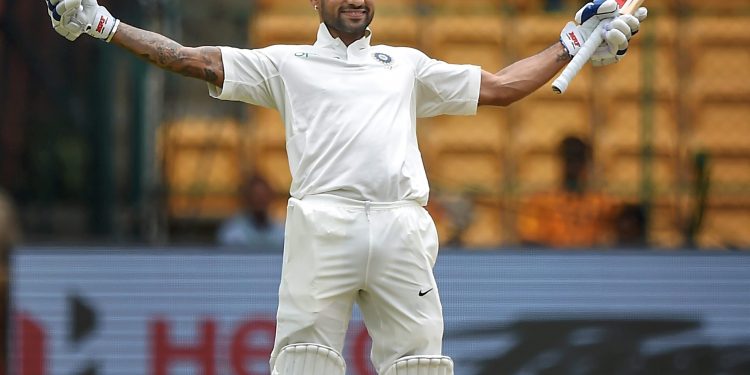 Shikhar Dhawan celebrates his century on the first day of the one-off cricket test match against Afghanistan, at Chinnaswamy Stadium, Thursday