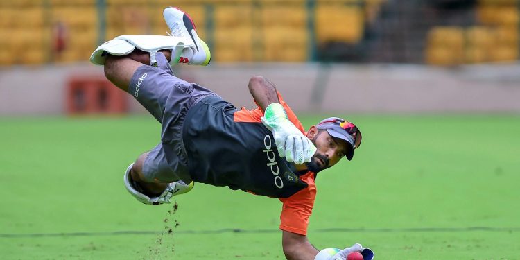 Dinesh Karthik dives for a catch during a practice session ahead of their maiden cricket Test match against Afghanistan, in Bangalore Monday