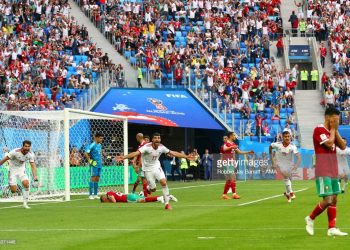 Morocco’s Aziz Bouhaddouz (C) lies on the ground after scoring an own goal as Iran players celebrate a thrilling win at St Petersburg, Friday