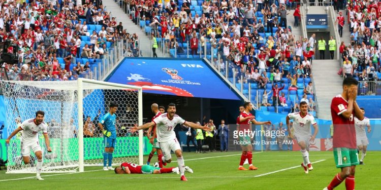 Morocco’s Aziz Bouhaddouz (C) lies on the ground after scoring an own goal as Iran players celebrate a thrilling win at St Petersburg, Friday
