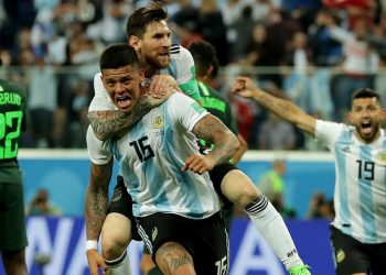 Lionel Messi on the back of Marcus Rojo celebrates after the latter’s goal against Nigeria, Tuesday night 