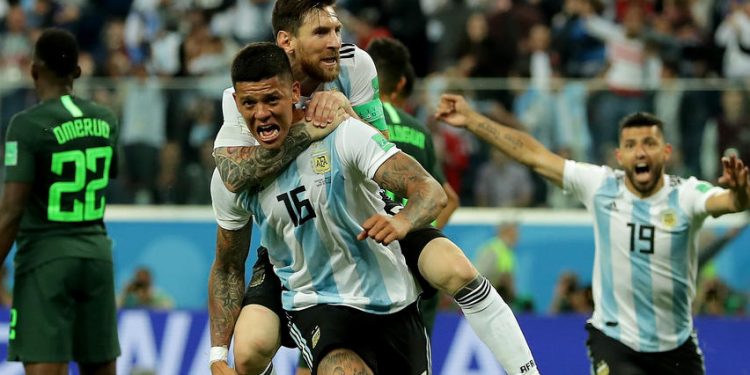Lionel Messi on the back of Marcus Rojo celebrates after the latter’s goal against Nigeria, Tuesday night 