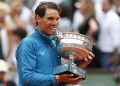 Spain's Rafael Nadal bites the cup the after defeating Austria's Dominic Thiem in the men's final match of the French Open tennis tournament at the Roland Garros stadium, Sunday