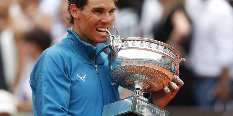 Spain's Rafael Nadal bites the cup the after defeating Austria's Dominic Thiem in the men's final match of the French Open tennis tournament at the Roland Garros stadium, Sunday