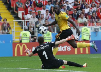 Belgium’s Romelu Lukaku tucks the ball past Tunisian goalkeeper Farouk Ben Mustapha to score his side’s third goal, Saturday 