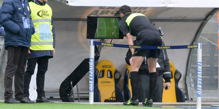 A referee looks at the TV screen closely for video assisting during a Serie A match in Italy