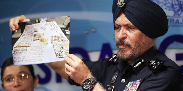 Kuala Lumpur : Malaysia's commercial crime investigations chief Amar Singh shows a picture of jewelry during a press conference in Kuala Lumpur, Malaysia, Wednesday, June 27, 2018. Malaysian police say the total value of cash, jewelry and hundreds of watches and handbags seized from properties linked to former Prime Minister Najib Razak in a money-laundering investigation amounted to $273 million. AP/PTI Photo(AP6_27_2018_000076B)