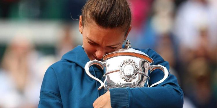 Simona Halep holds tight the Suzanne-Lenglen Cup after winning the French Open women’s singles title, Saturday