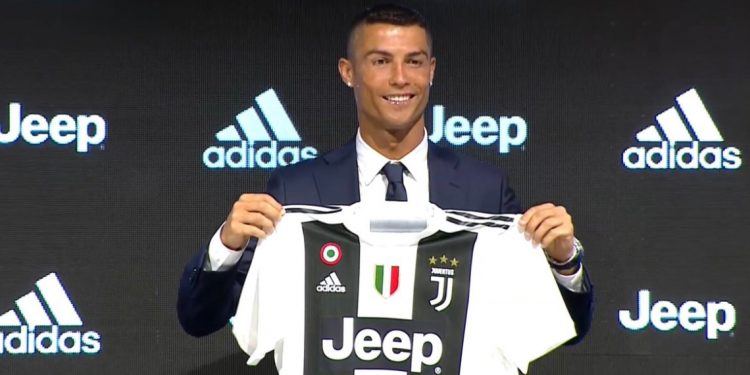 Cristiano Ronaldo poses with his Juventus jersey during his unveiling in Turin, Monday