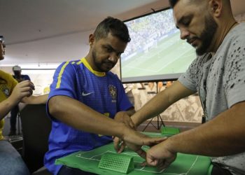 Carlos Junior (in blue) takes the help from interpreter Helio Fonseca de Araujo (R) during the Brazil versus Mexico match, Monday