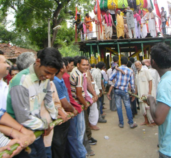Devotees pulling chariot using bamboos