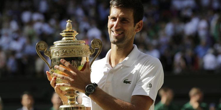 Novak Djokovic holds the trophy after defeating Kevin Anderson of South Africa in the men's singles final match at the Wimbledon Tennis Championships in London, Sunday