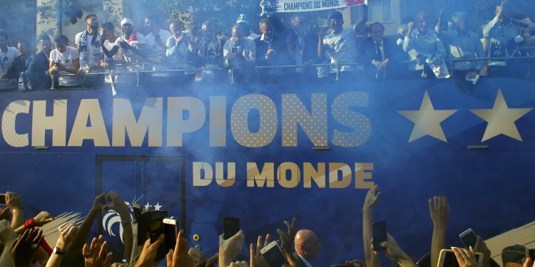 France's victorious World Cup team descends in a bus upon Paris' packed Champs-Elysees avenue upon their return from Russia