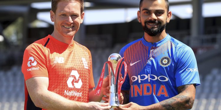 England's Eoin Morgan (L) and India's Virat Kohli pose with the series trophy at The Old Trafford in Manchester, Monday