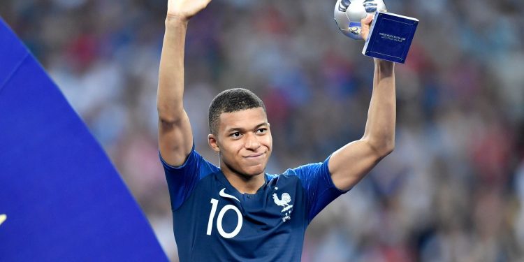 Teenage sensation: France’s Kylian Mbappe holds the ‘Best Young Player at the World Cup’ trophy aloft as he receives applause from fans after winning the tournament