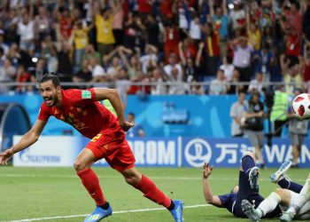 Nacer Chadli wheels away in celebration after scoring the winning goal for Belgium with the Japanese goalkeeper and a defender lying prostrate