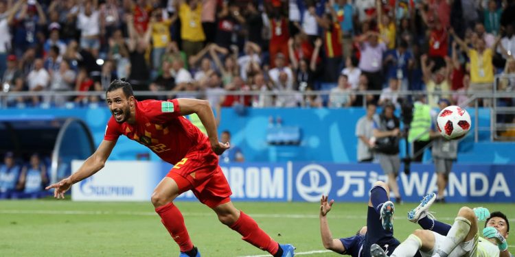 Nacer Chadli wheels away in celebration after scoring the winning goal for Belgium with the Japanese goalkeeper and a defender lying prostrate