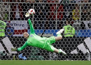 England goalkeeper Jordan Pickford dives to keep out Colombia’s Carlos Bacca’s shot during the shootout, Tuesday