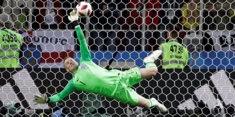 England goalkeeper Jordan Pickford dives to keep out Colombia’s Carlos Bacca’s shot during the shootout, Tuesday