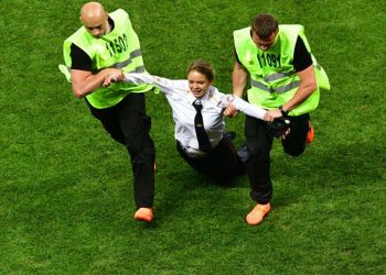 Security personnel drag away one of the persons who ran on to the pitch during the final of the World Cup