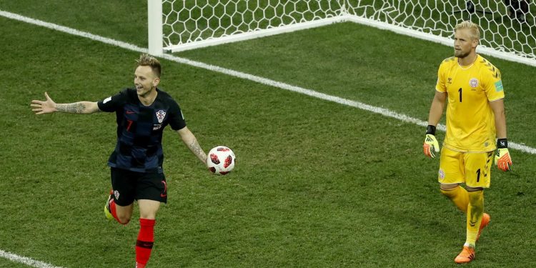 Ivan Rakitic wheels away in celebration after scoring the winning goal for Croatia with Danish goalkeeper Kasper Schmeichel on his hunches   