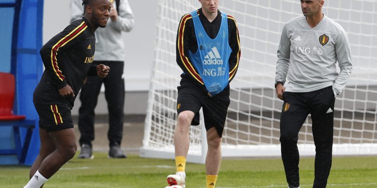 Belgium coach Roberto Martinez  R) speaks with Kevin De Bruyne (2nd L) as Michy Batshuayi shoots the ball during their training session, Wednesday