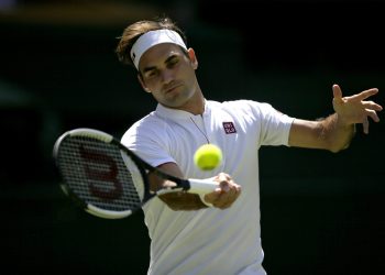 Roger Federer returns the ball to Dusan Lajovic during their men's Singles first round match at the Wimbledon Tennis Championships in London, Monday