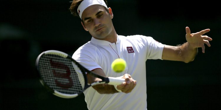 Roger Federer returns the ball to Dusan Lajovic during their men's Singles first round match at the Wimbledon Tennis Championships in London, Monday