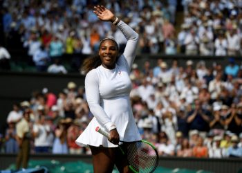 A smiling Serena Williams acknowledges the applause of the Wimbledon centre court crowd with the runner-up plate, Saturday