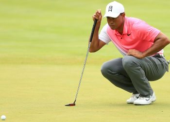 Tiger Woods inspects the lay of the green before taking his shot Friday