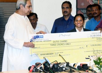 Chief Minister Naveen Patnaik hands a cheque of rupees three crore to Dutee Chand at the state Secretariat