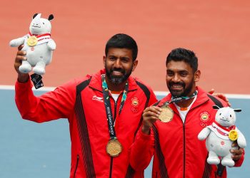 Gold medallists Rohan Bopanna and Divij Sharan celebrate with their medals and plush mascots.