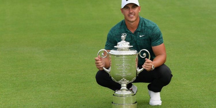 Brooks Koepka poses with the winner's trophy