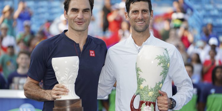 Novak Djokovic (R) and Roger Federer poses with their respective trophies after the final at Cincinnati, Sunday