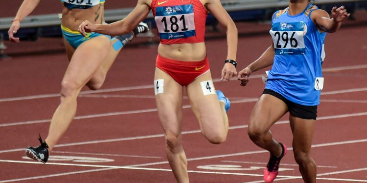 Dutee Chand (R) crosses the finish line to win the silver medal in the women's 200m final event at the Asian Games