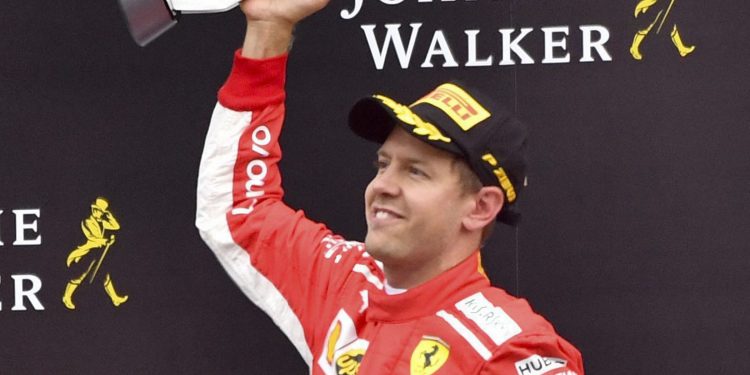 Ferrari driver Sebastian Vettel jubilates with his trophy on the podium after winning the Belgian Grand Prix Spa-Francorchamps
