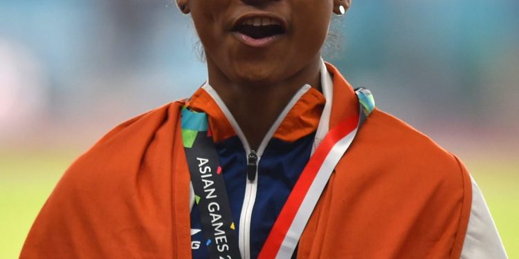 Indian athlete Hima Das celebrates after securing silver medal in the women's 400m final on Athletics track event at the Asian Games