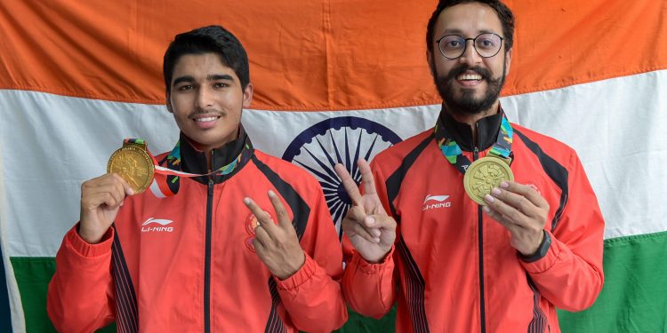 Gold medal winner Saurav Chaudhary (L) and bronze medallist Abhishek Verma pose for photographs during the medal presentation ceremony of men's 10m air pistol event at the Asian Games in Palembang