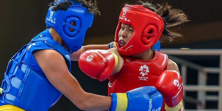 Naorem Roshibina Devi (red) fights China's Cai Yingying at the Asian Games in Jakarta