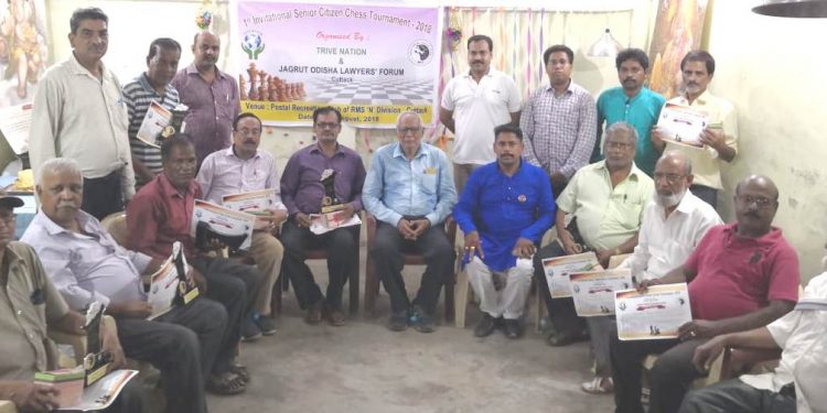 Winners of the Invitational Senior Citizen Chess Championship pose with their trophies and certificates along with guests in Cuttack, Friday