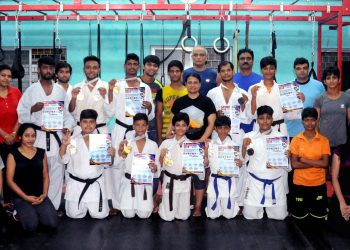 Karatekas pose with their medals and certificates at Utkal Karate School in Bhubaneswar, Tuesday