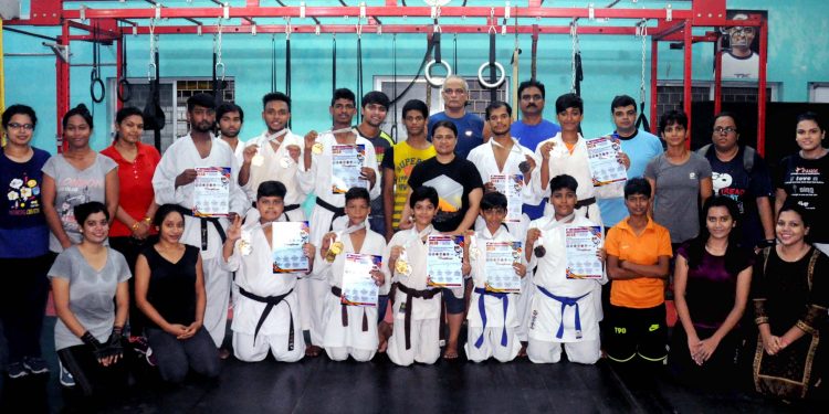 Karatekas pose with their medals and certificates at Utkal Karate School in Bhubaneswar, Tuesday